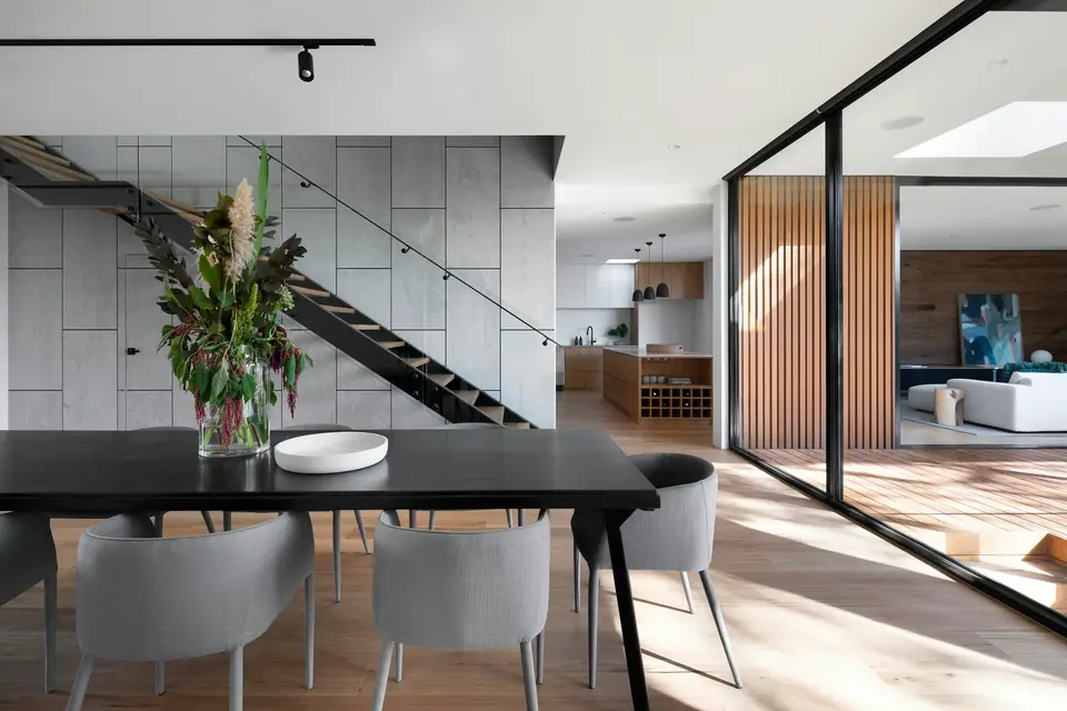 Dining room with sculptural staircase and floral centerpiece